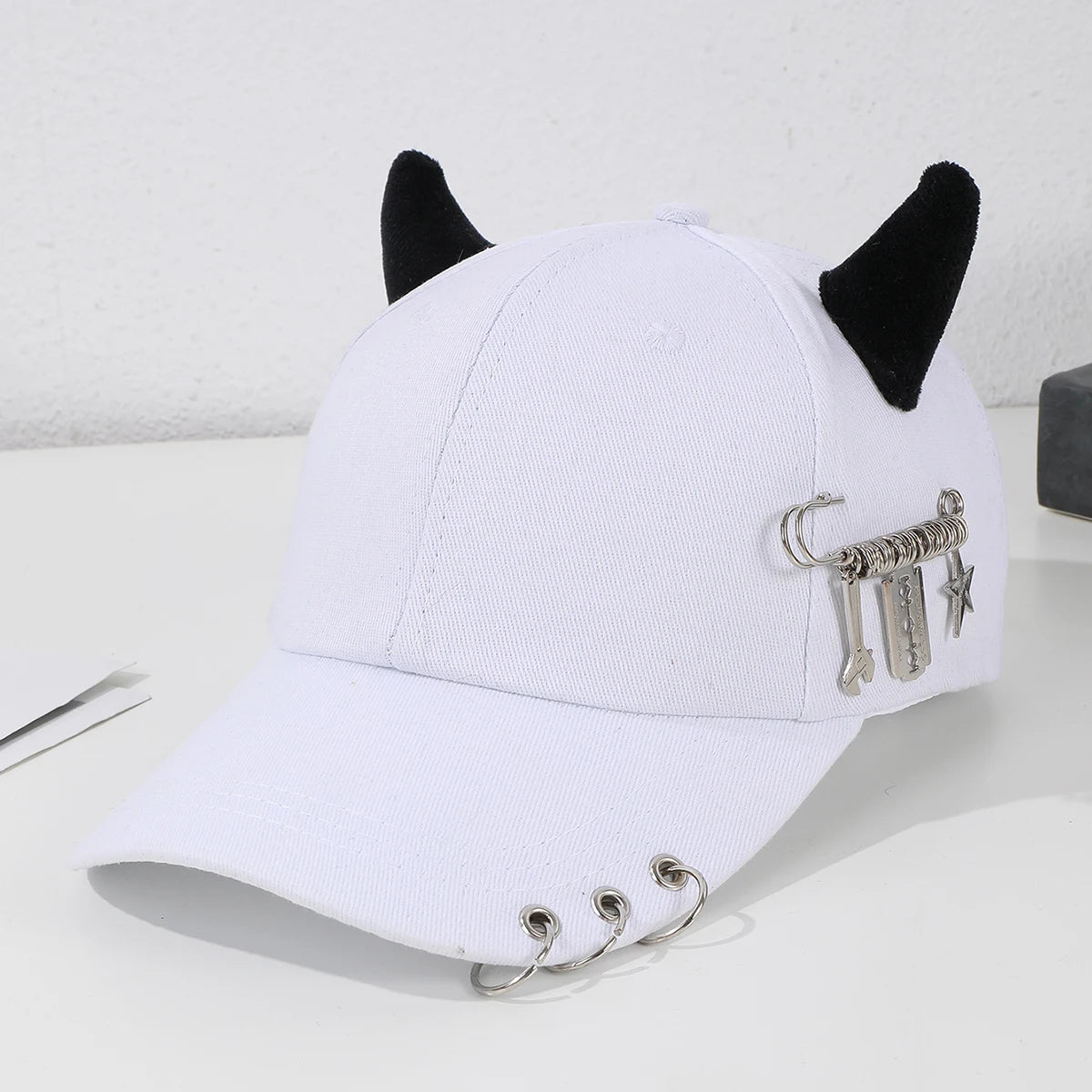 Modebroche i metal i form af en hoop, dekoreret i hiphop-stil, med hornmotiv, baseballkasket, udendørs, afslappet og sjov hat